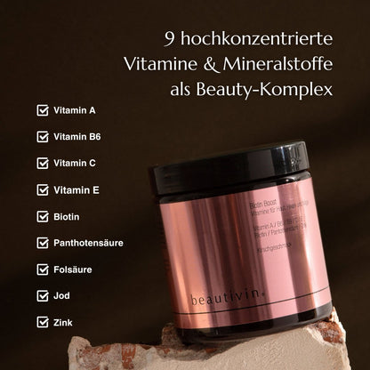 Eine roségoldene Dose Beautivin Biotin Boost steht auf einem Stein. Links daneben befindet sich eine Liste der enthaltenen Vitamine und Mineralstoffe, die als Teil des Beauty-Komplexes beschrieben werden: Vitamin A, Vitamin B6, Vitamin C, Vitamin E, Biotin, Pantothensäure, Folsäure, Jod und Zink. Oben steht der Text: ‚9 hochkonzentrierte Vitamine & Mineralstoffe als Beauty-Komplex‘